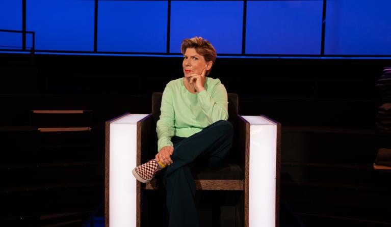 Vrouw zit in een stoel met haar hand onder haar hoofd