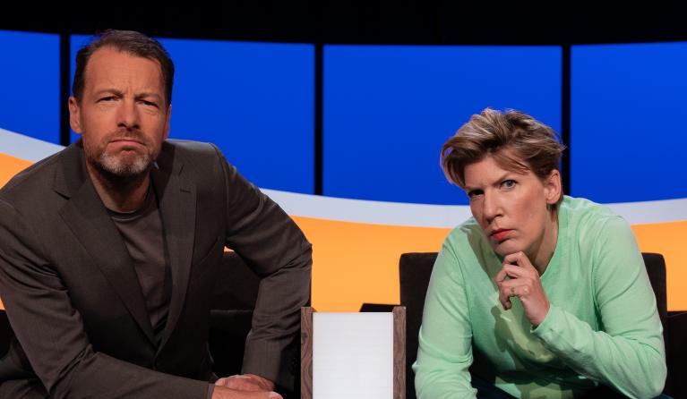 Man en vrouw in studio kijken serieus