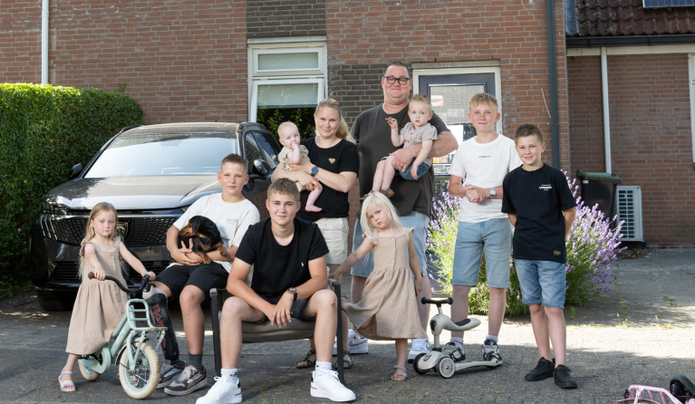 De familie De Lange uit Een huis vol poseert voor een huis