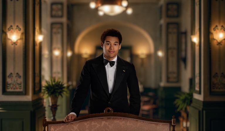 Een man in pak poseert in een luxe hotel