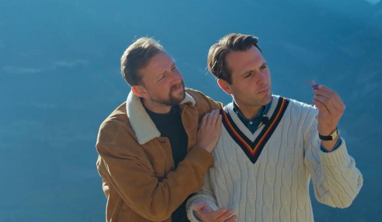 Twee mannen kijkend naar een paars ding