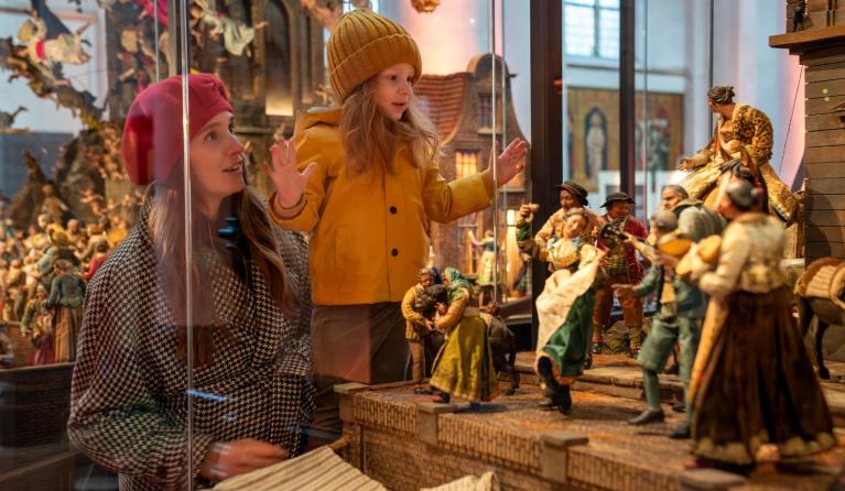 Meisje en vrouw kijken naar kerststal