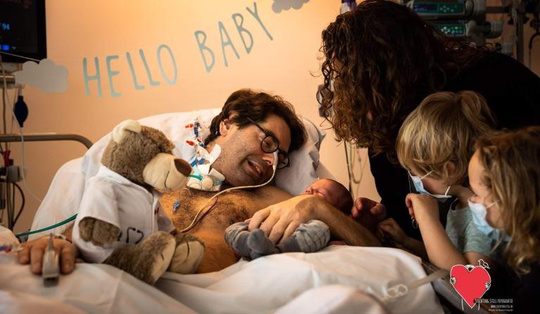 Hans in ziekenhuisbed met baby