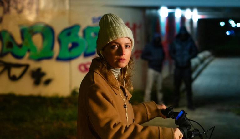 een vrouw op een fiets bij een tunnel