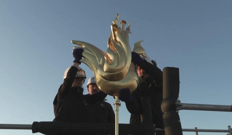 This image grab taken from an AFP TV video shows the new golden rooster containing relics being installed atop the spire of Notre Dame cathedral as part of its reconstruction, in central Paris on December 16, 2023. The golden rooster contains relics saved from the fire that struck the monument on April 15, 2019, and a document with the names of those working on its reconstruction. Gaspard FLAMAND / AFP