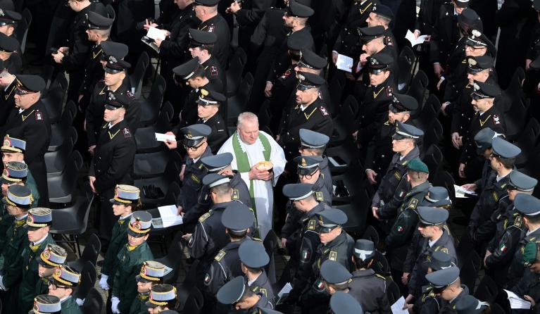 A priest gives communion to members of the armed forces as Pope Francis celebrates the mass for the Jubilee of the Armed Forces at St. Peter's square in the Vatican on February 9, 2025. Alberto PIZZOLI / AFP