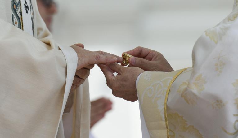 This photo taken and handout on May 18, 2025 by The Vatican Media shows Filipino cardinal Luis Antonio Gokim Tagle putting the Fisherman's Ring on a finger of Pope Leo XIV during a Holy mass for the beginning of his pontificate, in St Peter's square in The Vatican. Handout / VATICAN MEDIA / AFP