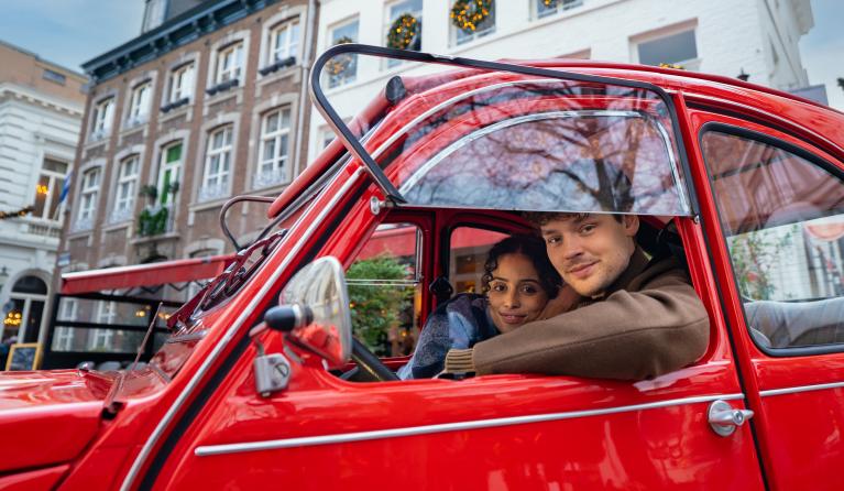 twee mensen in een rode auto