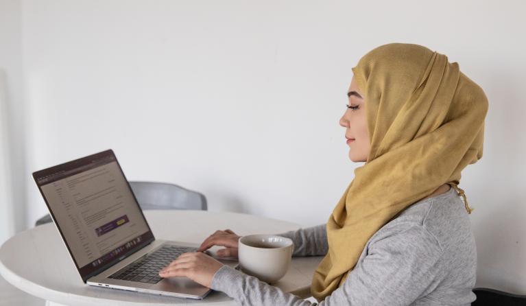 Meisje aan een tafeltje met een laptop