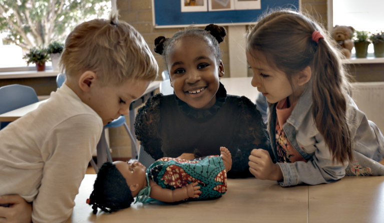 Nyah Nameh met een pop in de klas