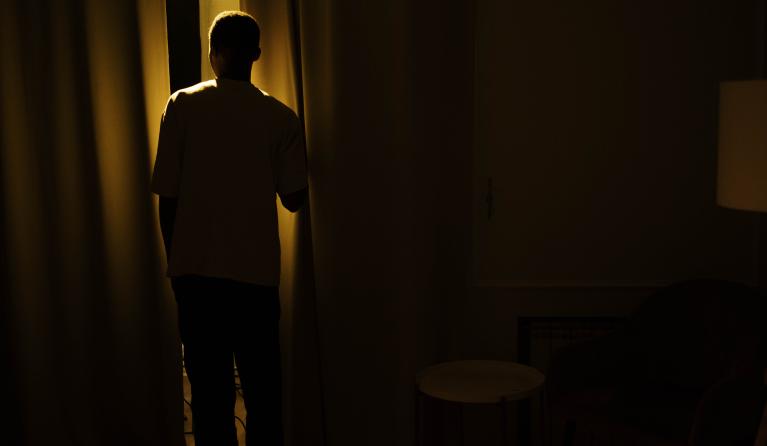 man in donker bij raam