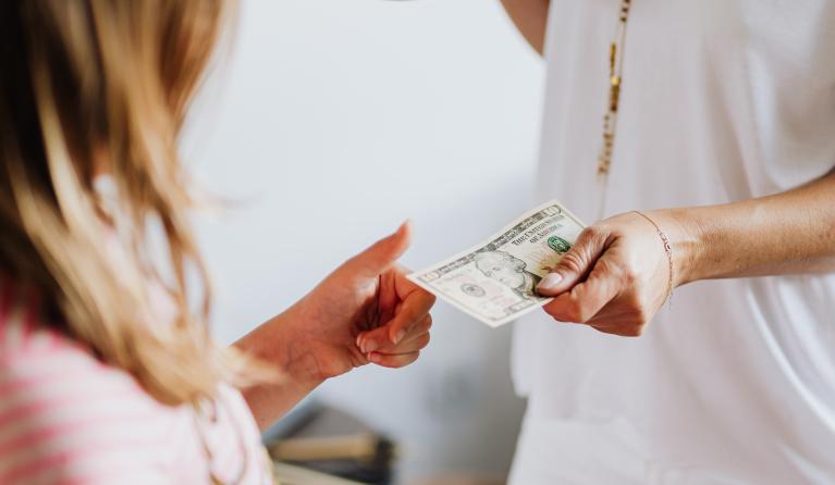 Vrouw geeft kind geld