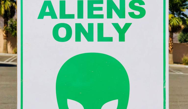 Een groene alien op een bord