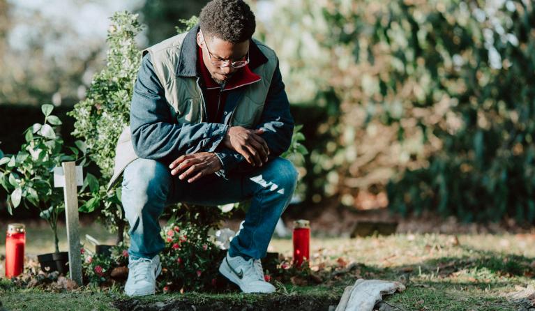 Man zit bij een open graf