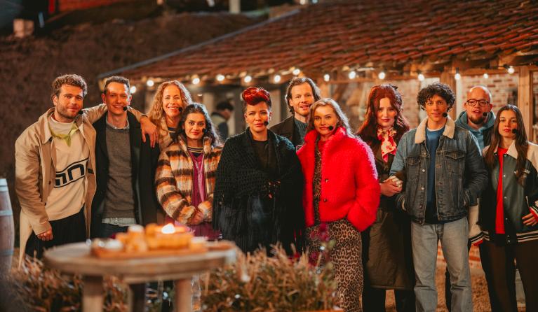 Groep mensen staat buiten en kijkt in de camera