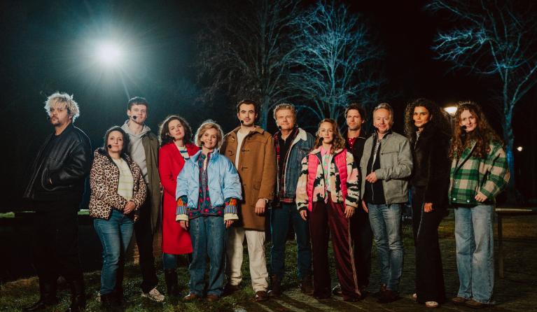 Groep acteurs geposeerd in het donker