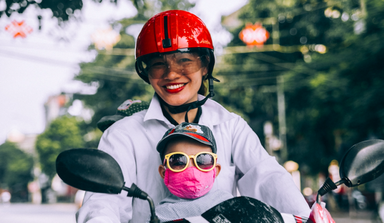 Vrouw met kindje op motor
