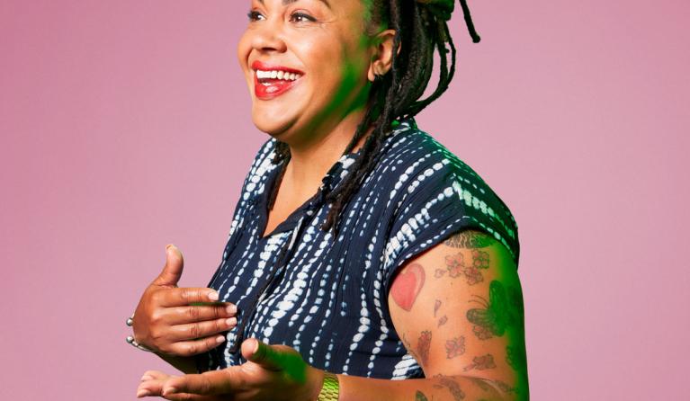 Sharon de Miranda voor een paarse achtergrond lachend