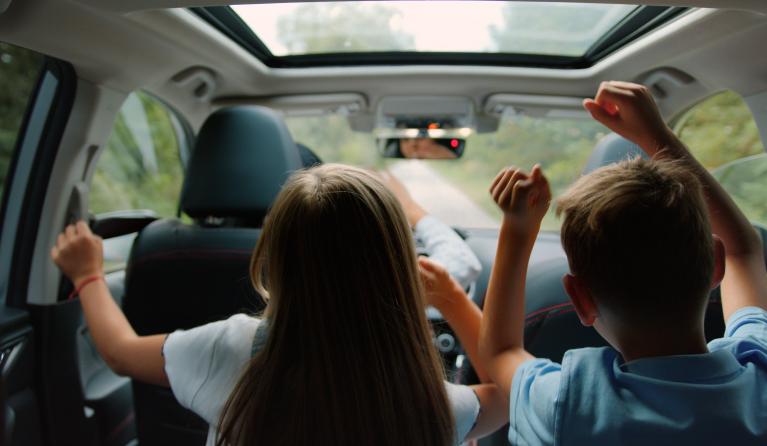 Twee vrolijke kinderen op de achterbank van een auto