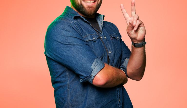 Tim Hogenbosch poseert voor een zalmroze achtergrond