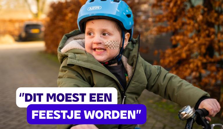 een jongetje met helm op een fietsje