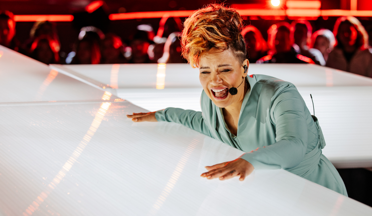 Vrouw zingend terwijl ze leunt op een kruis