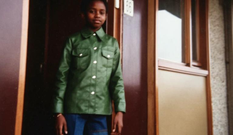 Meisje met groene jas in deuropening