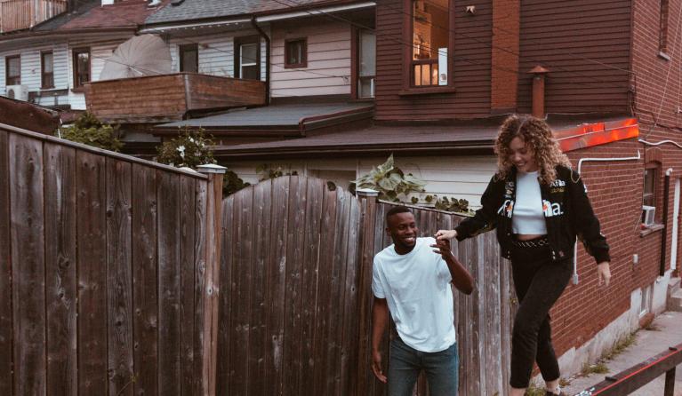 vrouw loopt op een balk en een mand houdt haar vast