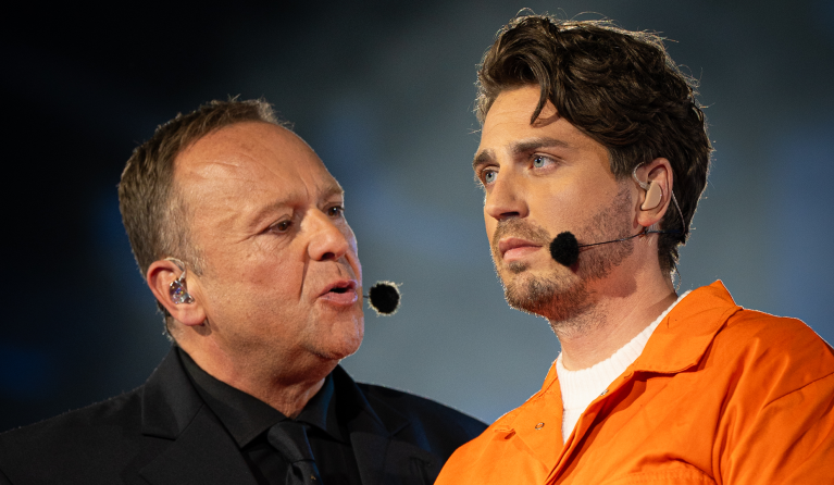 Man kijkt naar een andere man op het podium