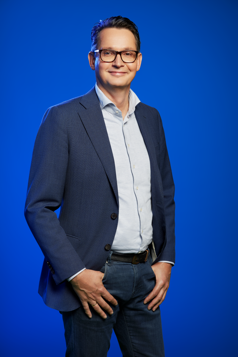 Arie Koornneef voor een blauwe achtergrond