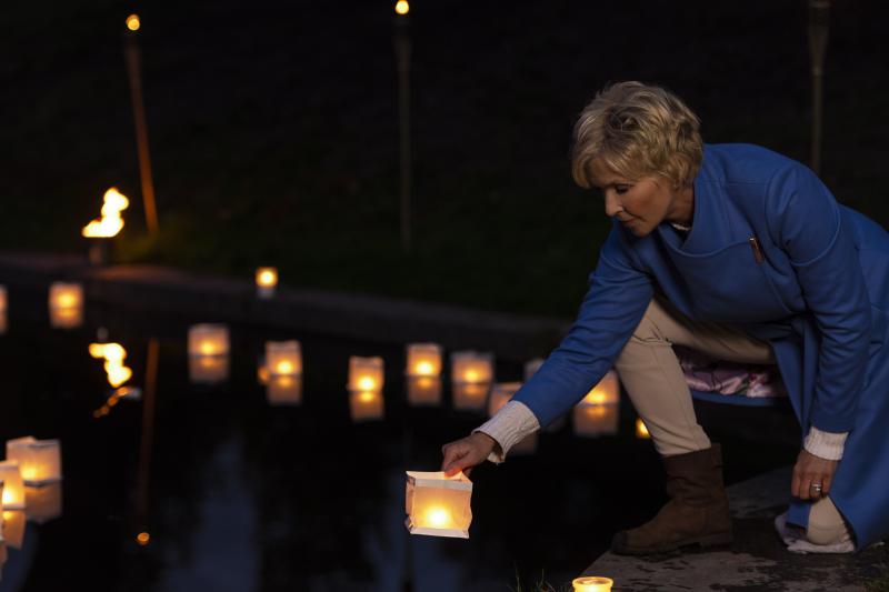 Anita steekt kaarsje aan op het water