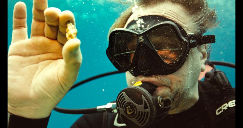 Man met duikpak en duikbril in oceaan