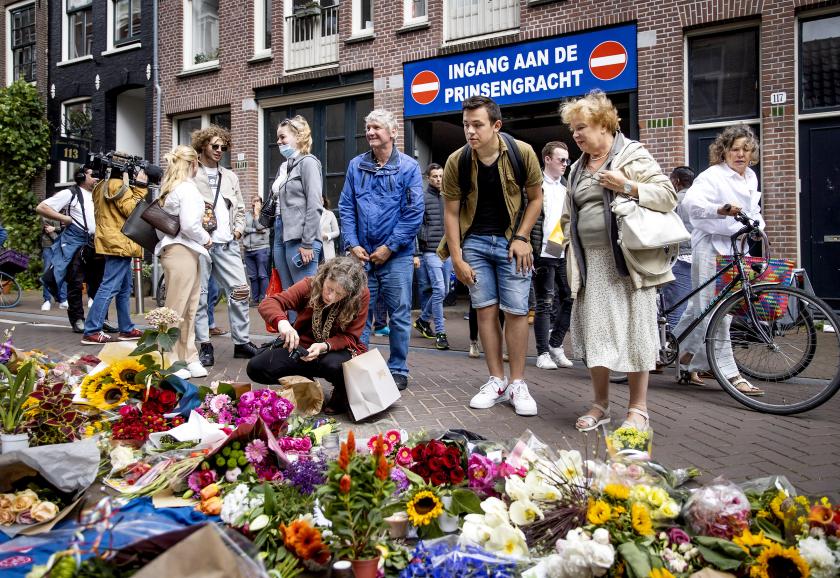 Mensen laten bloemen, kaarsjes en steunbetuigingen aan Peter R. de Vries achter in de Lange Leidsedwarsstraat in het centrum van Amsterdam. De misdaadverslaggever ligt zwaargewond in het ziekenhuis, na een aanslag op zijn leven. ANP KOEN VAN WEEL Mensen laten bloemen, kaarsjes en steunbetuigingen aan Peter R. de Vries achter in de Lange Leidsedwarsstraat in het centrum van Amsterdam. De misdaadverslaggever ligt zwaargewond in het ziekenhuis, na een aanslag op zijn leven.