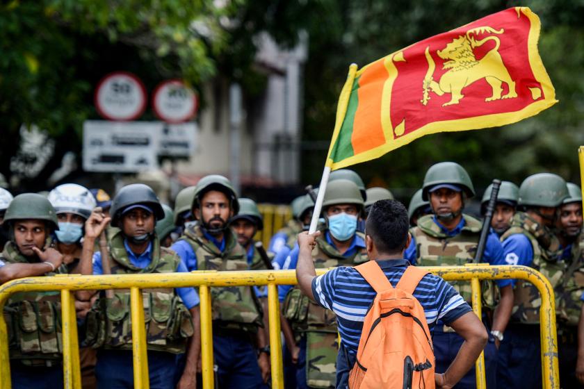 A demonstrator waves a Sri Lankan flag near police barriacdes during a protest march towards the Presidential secretariat office against Sri Lankan President Ranil Wickremesinghe, in Colombo on July 22, 2022. Arun SANKAR / AFP A demonstrator waves a Sri Lankan flag near police barriacdes during a protest march towards the Presidential secretariat office against Sri Lankan President Ranil Wickremesinghe, in Colombo on July 22, 2022. AFP