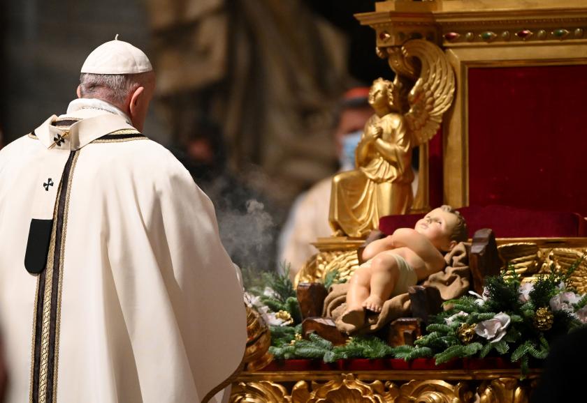 Paus Franciscus bij een beeldje van het Kerstkind bij aanvang van de nachtmis. Kerst 2020