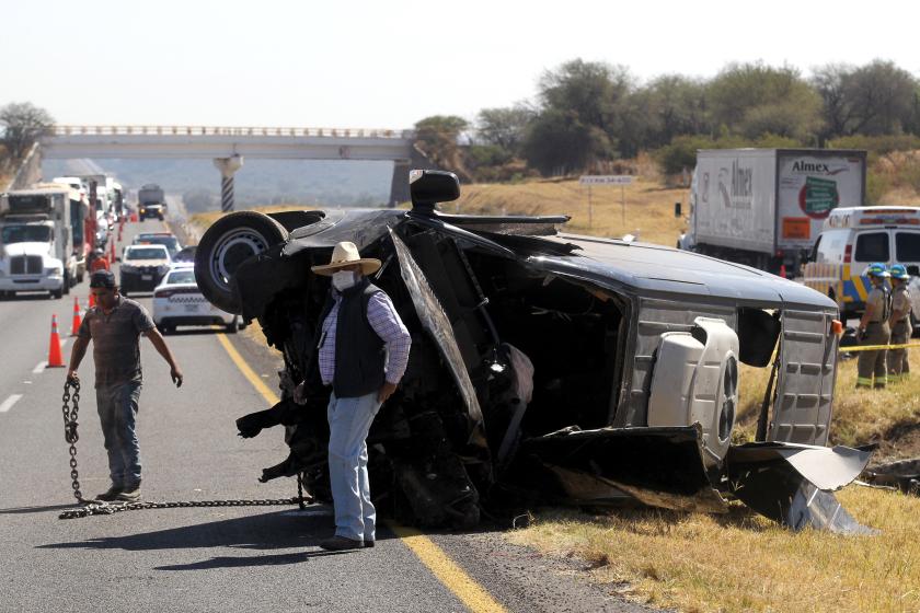 Rescue and forensic teams work at the scene of a road accident in which 12 members of the same family died and 11 other people were injured in Lagos de Moreno, state of Jalisco Mexico, on January 29, 2022. 
ULISES RUIZ / AFP Rescue and forensic teams work at the scene of a road accident in which 12 members of the same family died and 11 other people were injured in Lagos de Moreno, state of Jalisco