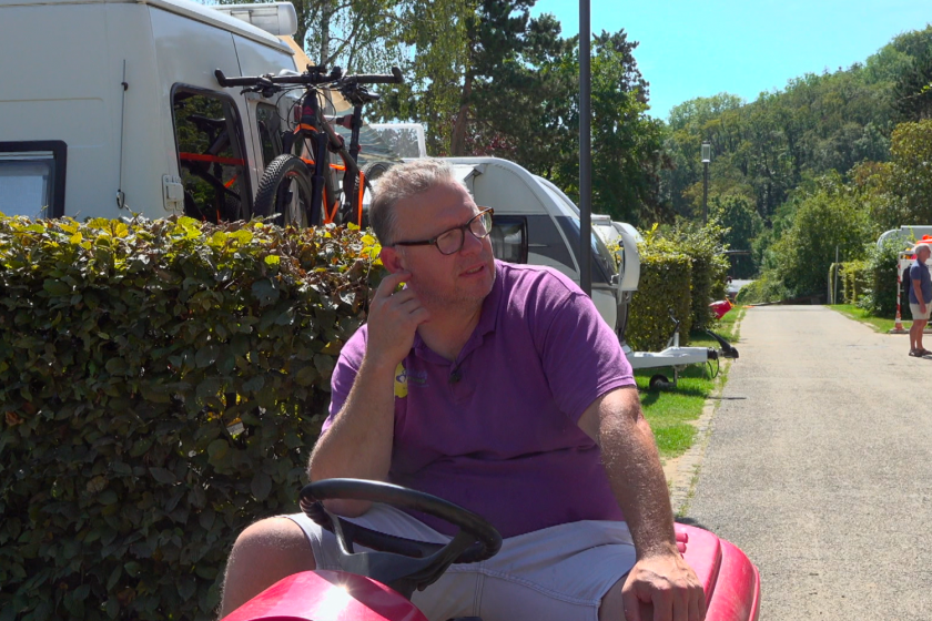 Ivan op de grasmaaier op de camping Een man met paars shirt op een grasmaaier op een camping