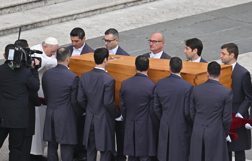 Pope Francis pays his respect as he touch the coffin of Pope Emeritus Benedict XVI during his funeral mass at St. Peter's square in the Vatican, on January 5, 2023. Pope Francis is presiding on January 5 over the funeral of his predecessor Benedict XVI at the Vatican, an unprecedented event in modern times expected to draw tens of thousands of people. Alberto PIZZOLI / AFP