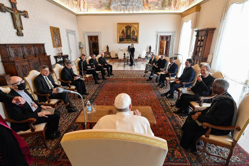 This photo taken and handout on March 26, 2021 by The Vatican Media shows Pope Francis (Front C) meeting with members of the Vatican's Covid-19 Commission in The Vatican. During the upcoming Holy Week, additional doses of the Pfizer-BioNTech vaccine, purchased by the Vatican and offered by the Lazzaro Spallanzani Hospital, through the Vatican Covid-19 Commission, will be destined for the vaccination of 1,200 of the poorest and most marginalized people. Last January, when the anti Covid-19 vaccination campaign began in the Vatican, Pope Francis wanted that among the first people vaccinated were over twenty-five poor people, mostly homeless, who live around St. Peter's and who are daily assisted and welcomed by the assistance and residence facilities of the Apostolic Elemosineria. Handout / VATICAN MEDIA / AFP Corona Commissie Vaticaan