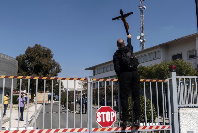 A Cypriot demonstrator raises a large cross at the entrance of the Cyprus Broadcasting Corporation (RIK) headquarters in the capital Nicosia on March 6, 2021, during a protest against the controversial Eurovision Song Contest entry "El Diablo" by a Greek singer representing Cyprus. The song "El Diablo" (Spanish for the devil), performed by Greek singer Elena Tsagrinou, has faced criticism since its release last week. The Holy Synod, the Cyprus Orthodox Church's highest decision-making body, said the song "essentially praises the fatalistic submission of humans to the devil's authority". Iakovos Hatzistavrou / AFP Gelovigen betogen op Cyprus tegen songfestivalinzending