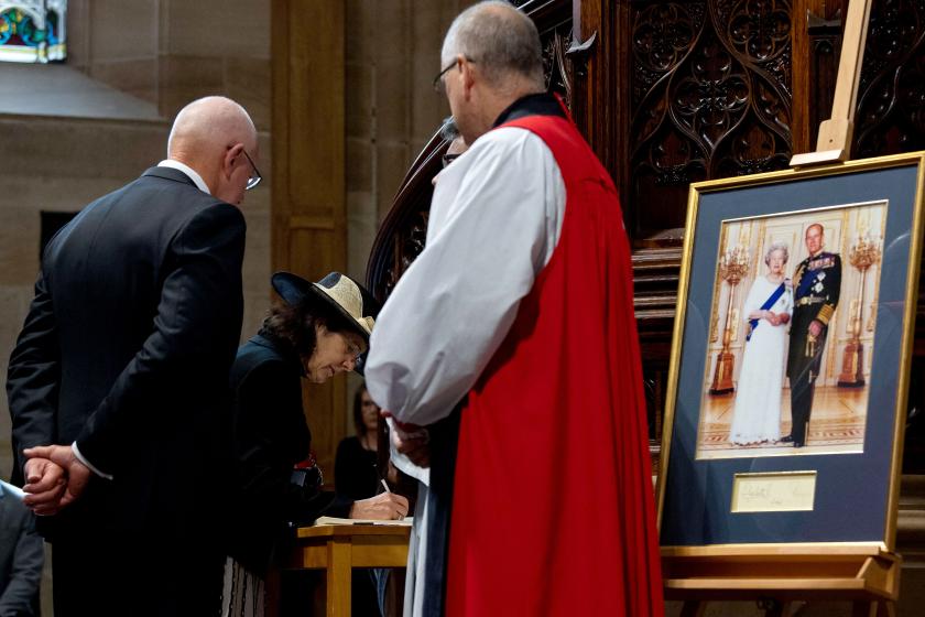 Gouverneur-generaal David Hurley (L) wacht terwijl zijn vrouw Linda Hurley (2e L) een condoleanceregister tekent tijdens een dienst ter herdenking van de dood van prins Philip, hertog van Edinburgh, in de St Andrew's Cathedral in Sydney op 11 april 2021. herdenking Philip in Sydney
