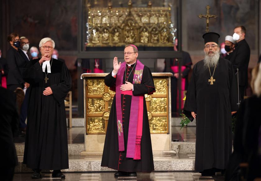 Georg Baetzing (C), Chairman of the German Bishops' Conference, Radu Constantin Miron (R), Chairman of the Association of Christian Churches, and Heinrich Bedford-Strohm (L), Chairman of the Council of the Evangelical Church in Germany, pray together during the ecumenical service and memorial ceremony for the victims of the flood disaster in western Germany, at the Cathedral in Aachen, western Germany, on August 28, 2021 Oliver Berg / POOL / AFP Voorgangers in de dienst waren rk-bisschop Georg Bätzing van Limburg (m.), Grieks-orthodox aartspriester Radu Constantin Miron (r.), en evangelisch kerkleider Heinrich Bedford-Strohm (.).