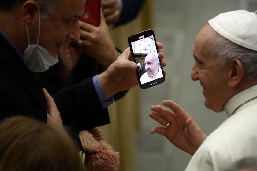 Pope Francis is seen through a phone after the general audience in the Paul VI Hall at the Vatican on December 22, 2021. Filippo MONTEFORTE / AFP Pope Francis is seen through a phone after the general audience in the Paul VI Hall at the Vatican on December 22, 2021.