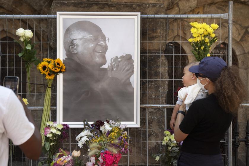 Mensen huldigen bisschop Tutu bij de St. Georges Cathedral in Kaapstad, 26-12-2021 (AFP Photo) People bring flowers to St. Georges Cathedral, where a Wall of Remembrance for of Desmond Tutu, Nobel Peace Laureate, has been set up after the news of his death, on December 26, 2021 Cape Town. RODGER BOSCH / AFP