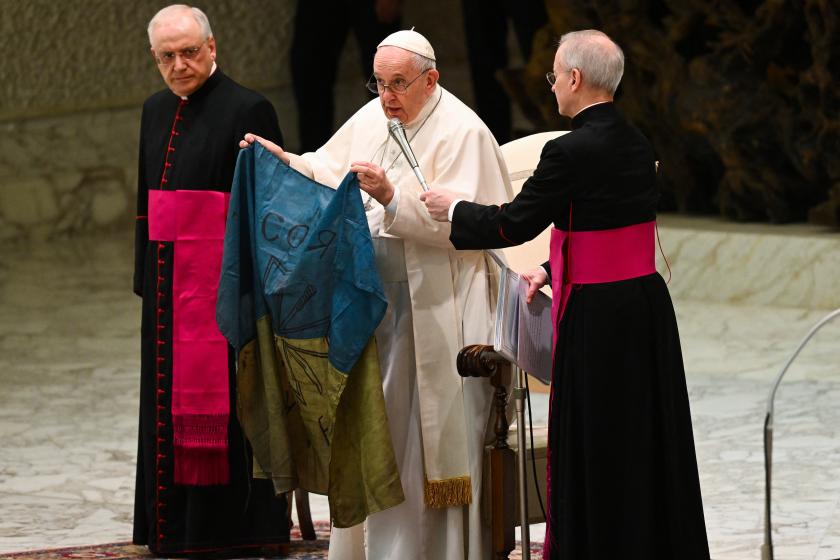 Pope Francis speaks while holding a flag of Ukraine that comes from the city of Bucha, one of the areas around Ukraine's capital from which Russian troops have withdrawn and where dozens of bodies in civilian clothing have been found, during the weekly general audience on April 6, 2022 at Paul-VI hall in The Vatican. Andreas SOLARO / AFP Pope Francis speaks while holding a flag of Ukraine that comes from the city of Bucha, one of the areas around Ukraine's capital from which Russian troops have withdrawn and where dozens of bodies in civilian clothing have been found, during the weekly general audience on April 6, 2022 at Paul-VI hall in The Vatican.
