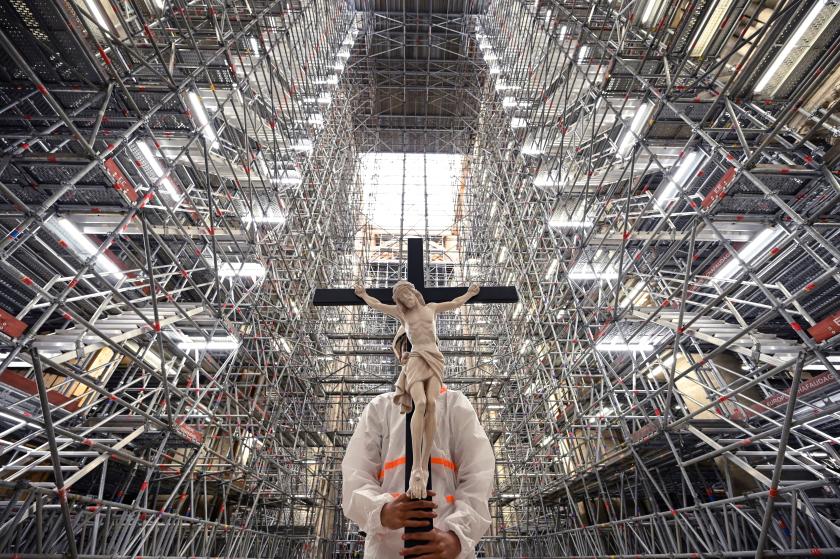 A catholic faithful holds a crucifix during a Good Friday Meditation prayer carried out by prelates in the Notre-Dame cathedral in Paris on April 15, 2022, marking the third anniversary of a fire that partially destroyed the cathedral. Bertrand GUAY / AFP A catholic faithful holds a crucifix during a Good Friday Meditation prayer carried out by prelates in the Notre-Dame cathedral in Paris on April 15, 2022, marking the third anniversary of a fire that partially destroyed the cathedral.