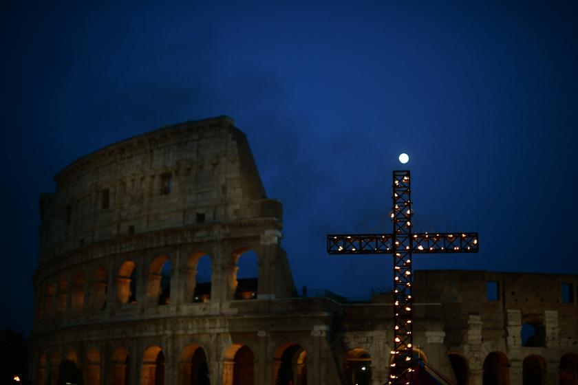 A view shows the cross as the moon rises over the Colosseum monument in Rome, prior to the Pope presiding over the Way of The Cross on Good Friday, April 15, 2022. Filippo MONTEFORTE / AFP A view shows the cross as the moon rises over the Colosseum monument in Rome, prior to the Pope presiding over the Way of The Cross on Good Friday, April 15, 2022. F