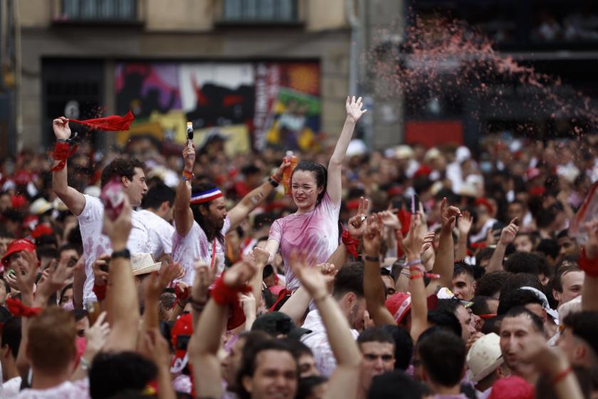 People celebrate in the Town Hall Square prior to the start of the San Fermin Festival in Pamplona, Spain, 06 July 2022. Thousands of people from all over the world are attracted by the event and even take the risk and challenge to join the traditional 'running of the bulls'. This year's San Fermin Festival runs from 06 to 14 July 2022. The event resumes after a two-year break due to the Covid-19 pandemic. EPA/RODRIGO JIMENEZ