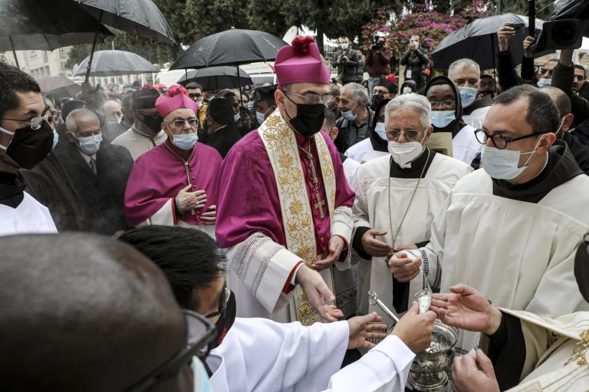 Archbishop Pierbattista Pizzaballa (C), Latin Patriarch of Jerusalem, arrives to attend Christmas celebrations at the Church of the Nativity in the biblical city of Bethlehem in the occupied West Bank on December 24, 2020, while mask-clad due to the COVID-19 coronavirus pandemic. JAAFAR ASHTIYEH / AFP Aankomst Latijnse patriarch in Bethlehem kerst 2020