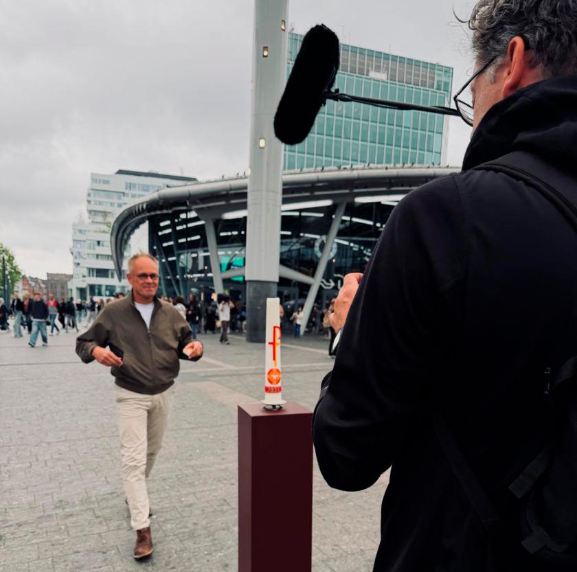Kees van Ekris steekt een kaars aan op het Stationsplein in Utrecht